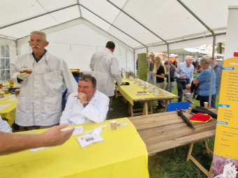 Keurmeesters in gesprek en aan het werk op de markt van Melk en Honing en Honingkeuringkeuring 2025