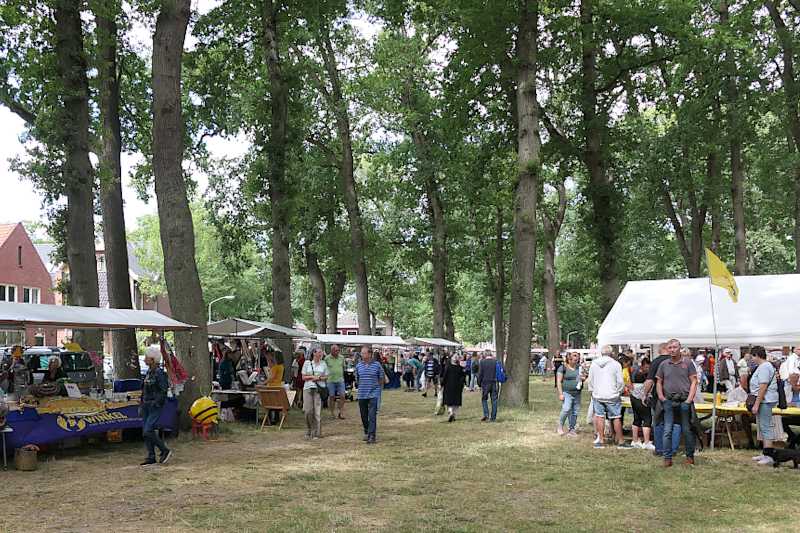 Doorkijkje naar de marktkramen onder de bomen en de tent van het Bijkersgilde   (klik voor vergroting)